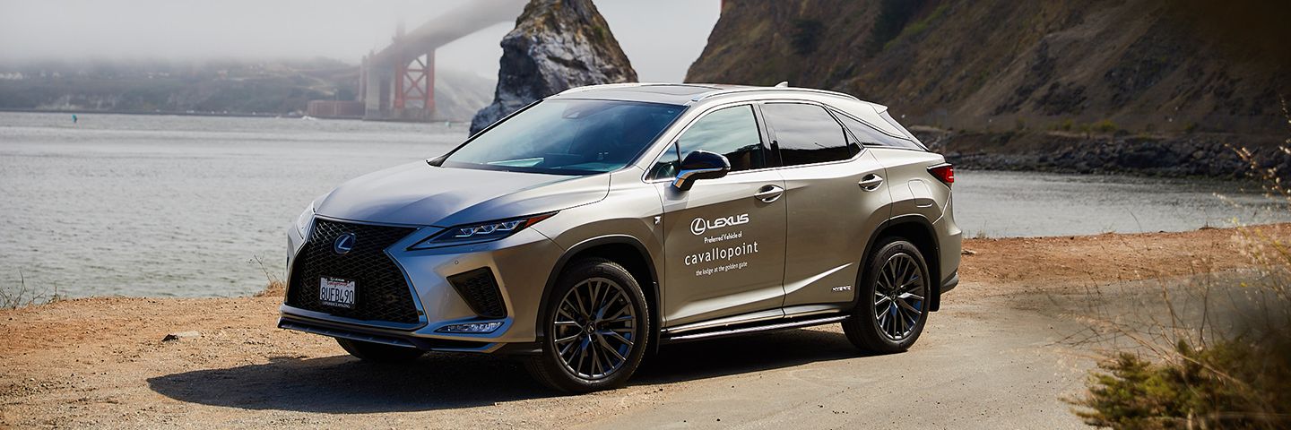 Silver Lexus SUV parked on a dirt path overlooking the Golden Gate Bridge in San Francisco.