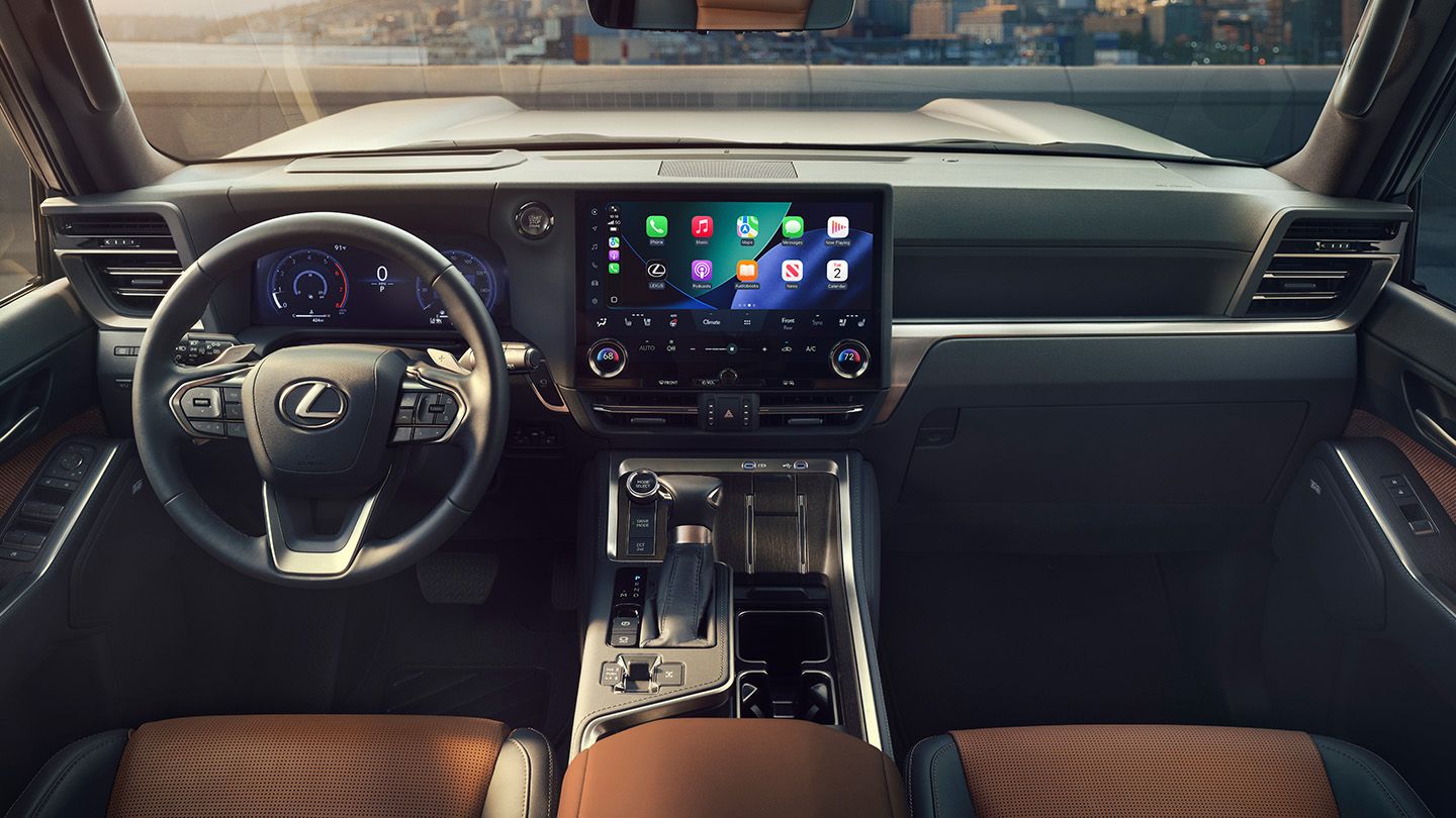 The front seating area and driver controls, including center-console touchscreen displaying smartphone interface.